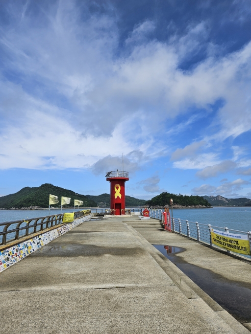 섬과 바다를 배경으로 한 등대가 있는 부두,